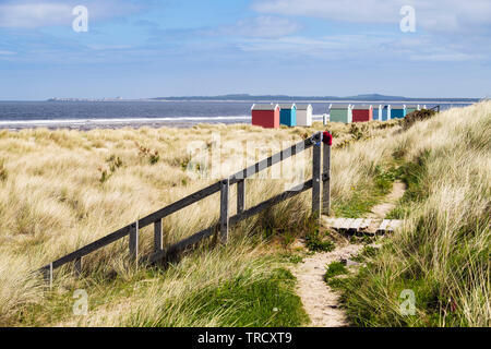 Pfad durch die Dünen und hölzerne Treppe Strand mit bunten Badekabinen am Moray Firth Küste zu. Findhorn, Moray, Schottland, Großbritannien, Großbritannien Stockfoto