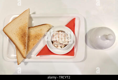 Gesundes Frühstück im Restaurant, Thunfisch mit zwei Toasts auf dem weißen Hintergrund Stockfoto