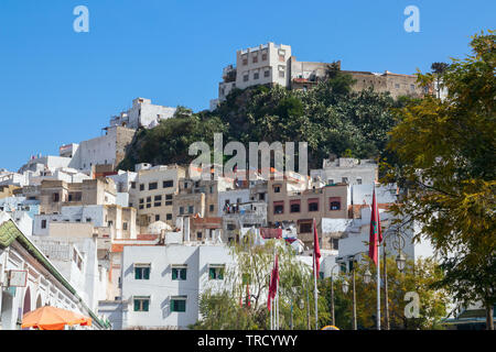 Hauptstraße von der kleinen Stadt Moulay Idriss mit weißen Häusern und Gebäuden auf einer Klippe. Marokko. Stockfoto