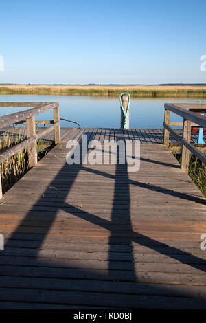 Alten hölzernen Steg mit Geländer und Holz- Stapel an der Ostsee Stockfoto