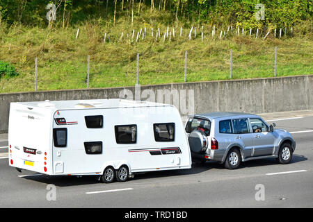 Seite Ansicht von oben der geladenen SUV-Familie Auto abschleppen eines weißen Elddis Avante/Achse Wohnwagen auf der Autobahn England Großbritannien Stockfoto