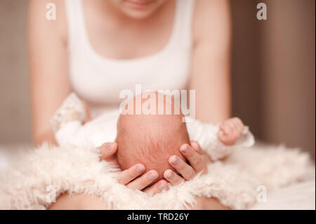 Mutter mit Kleinkind Baby auf Händen in Nahaufnahme. Die Mutterschaft. Mutterschaft. Die ersten Tage des Lebens. Stockfoto