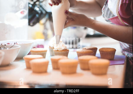 Frau, die cremige oben cupcakes Nahaufnahme. Selektive konzentrieren. Stockfoto