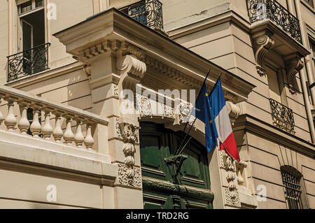 Französische Flagge oben Holztür auf ein altes Gebäude in einem bewölkten Tag in Paris. Einer der kulturellen Zentrum der eindrucksvollsten Welt in Frankreich. Stockfoto