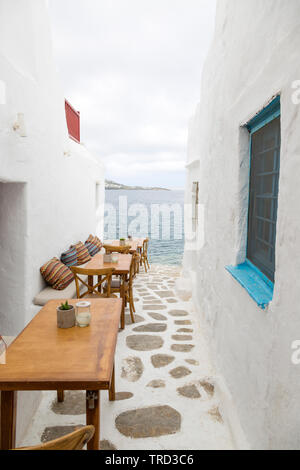 Auf der griechischen Insel Mykonos, gepflasterten Wegen mit Shop und Restaurant führen zum Meer. Stockfoto