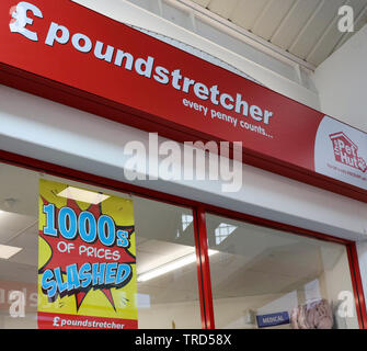 Fenster der Poundstretcher store mit Preisen zerschnitten und poundstretcher unterzeichnen und pethut Schild über Fenster. Stockfoto