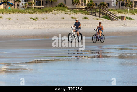 Active Senior Paar reiten Strand Fahrräder bei Sonnenaufgang am Jacksonville Strand im Nordosten von Florida. (USA) Stockfoto