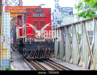 Zug, der auf alten Bahn auf Long Bien Brücke, dies ist die Bahnstrecke war so lange und heute noch in Betrieb in Hanoi, Vietnam gebaut Stockfoto