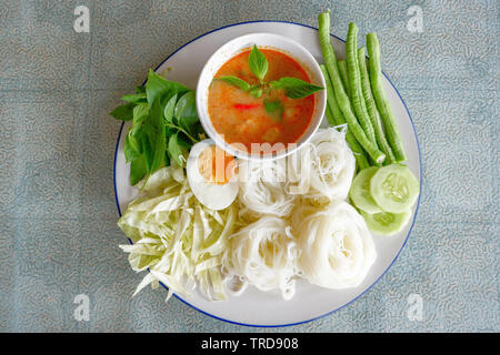 Weißer Reis oder Nudeln nudeln Nudeln und Suppe Curry Sauce auf Teller mit Gemüse yardlong, Gurke und Ei/Thai Essen lecker Stockfoto