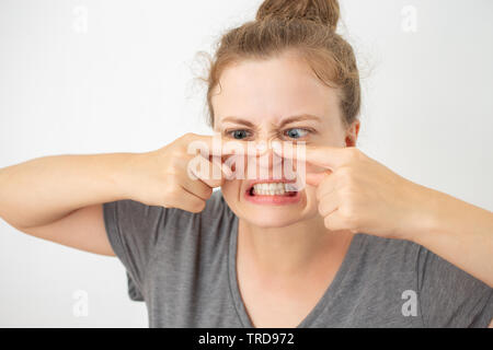 Junge kaukasier Frau quetschen ein Pickel auf der Nase, lustigen Gesichtsausdruck Stockfoto