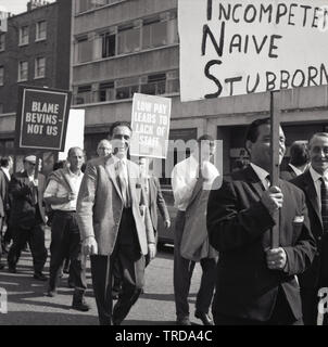 1960s, historische, streikende Royal Mail Postarbeiter, die mit Plakaten durch das Zentrum Londons laufen, ein Sprichwort: „Niedrige Bezahlung führt zu Personalmangel“. Die Postarbeiter der Niederlassung in Kilburn protestierten gegen niedrige Löhne und beschuldigen Bevin's für den Streik, der stattgefunden hat, und sagten, die ArbeiterInnen seien „inkompetent, naiv und stur“. Stockfoto