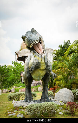 Khon Kaen, Thailand, 13. Mai 2018: Dinosaur Park/verschiedene Arten Dinosaurier Tyrannosaurus statue T Rex im Palmengarten Stockfoto