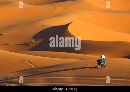 Berber in der Wüste Sand sitzen, Marokko, Merzouga, Erg Chebbi Stockfoto