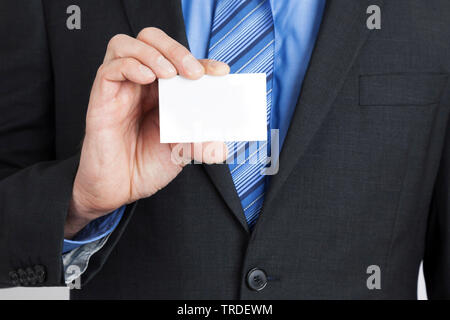 Close-up Portrait von einem Geschäftsmann in einem grauen Anzug Holding eine leere Namen Karte in seiner Hand. Stockfoto