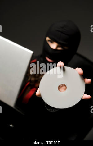 Porträt eines Business Frau bekleidet Skischablone holding Laptop und CD/Computerkriminalität Stockfoto