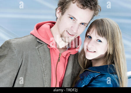 Porträt eines jungen Paares umarmen und in die Kamera lächeln im Freien Stockfoto