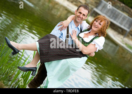 Porträt eines jungen Paares in traditionellen Kostümen vor einem Teich gekleidet Stockfoto