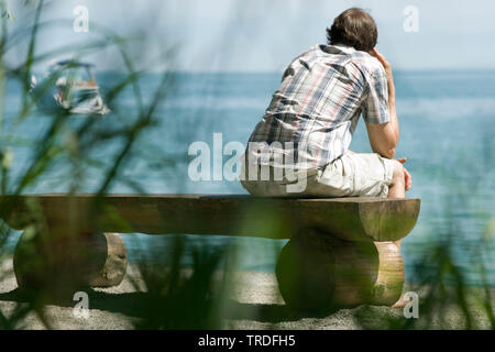 Porträt von einem nachdenklichen Mann sitzt auf einer Bank vor der See, Deutschland, Baden-Württemberg Stockfoto