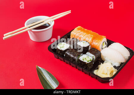 Sushi Rollen auf roten Hintergrund serviert. Japanisches Essen. Stockfoto