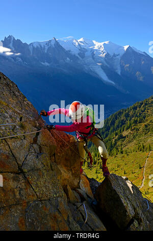 Weibliche Kletterer auf einem Felsen, via ferrata des Evettes, Mont Blanc im Hintergrund, Frankreich, Haute-savoie, Chamonix Stockfoto