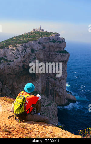 Wanderer sitzen am Rande eines speep Gesicht und am Leuchtturm von Capo Caccia, Italien, Sardinien, Alghero suchen Stockfoto