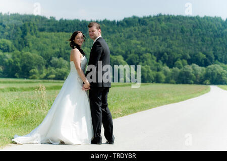 Hochzeit Bild von einem brautpaar halten sich an den Händen und Lächeln im Freien Stockfoto