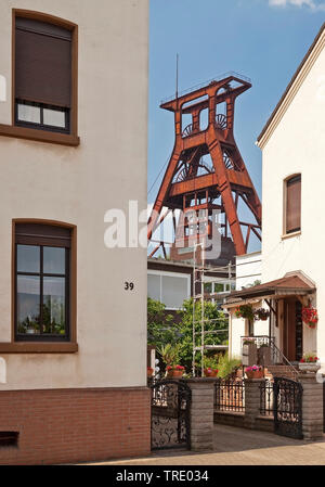 Wohnhäuser mit dem Fördergerüst der Zeche Pluto, Deutschland, Nordrhein-Westfalen, Ruhrgebiet, Herne Stockfoto