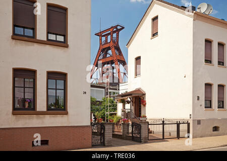 Wohnhäuser mit dem Fördergerüst der Zeche Pluto, Deutschland, Nordrhein-Westfalen, Ruhrgebiet, Herne Stockfoto