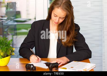 Portrait einer jungen Frau, die an einem Schreibtisch arbeiten Stockfoto
