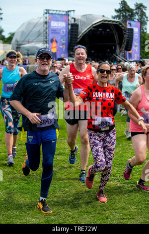 Tv-Moderatorin, Radio DJ und Geschäftsmann Chris Evans und seine Frau Natasha halten Hände, wie sie Teil in einem 5 km Laufen Rennen in Laufen Fest. Stockfoto