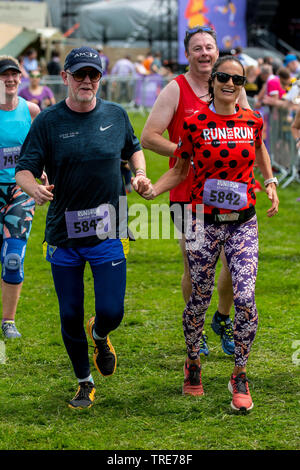 Tv-Moderatorin, Radio DJ und Geschäftsmann Chris Evans und seine Frau Natasha halten Hände, wie sie Teil in einem 5 km Laufen Rennen in Laufen Fest. Stockfoto