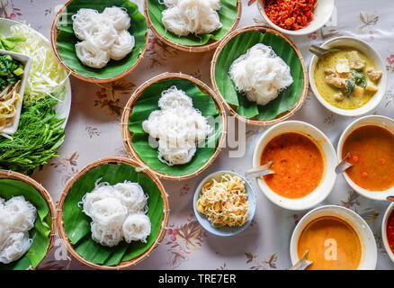 Satz von Thai Reis Nudeln fisch Sauce curry mit verschiedenen Suppen auf Schüssel und frisches Gemüse im thailändischen Stil Essen Nudeln Nudeln im Bananenblatt auf Tisch Stockfoto