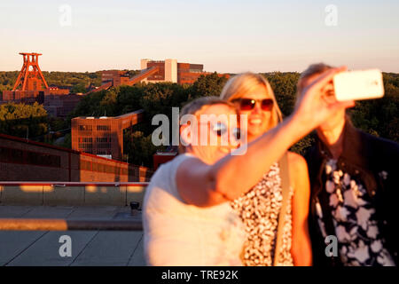 Drei Frauen, die eine selfie vor der Zeche Zollverein, Schacht XII, Deutschland, Nordrhein-Westfalen, Ruhrgebiet, Essen Stockfoto