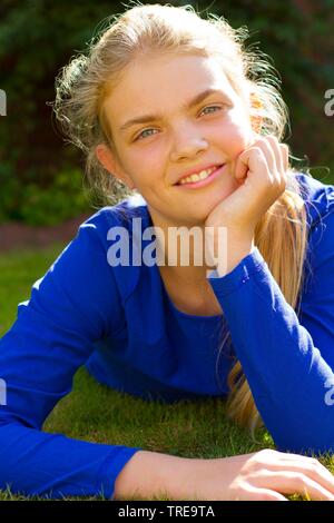 Junge Mädchen liegt auf dem Darlehen und ihren Kopf auf eine Hand Stockfoto