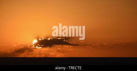 Einfach orange Sonnenuntergang hinter Wolken Stockfoto