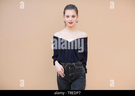 Lächelnd fashion model tragen marine blau Bluse beige Hintergrund Stockfoto