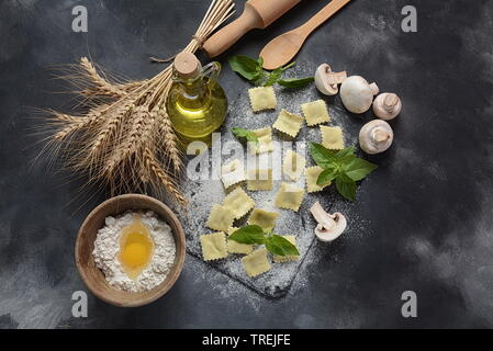 Italienische raw-Ravioli mit Pilzen, Basilikum, Mehl, Weizen, Olivenöl auf dunklem Hintergrund. Schawuot jüdische Feiertag essen Konzept Stockfoto