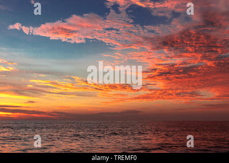 Sonnenuntergang von Wolken über dem Meer Fläche bei Alleppey Strand Indien. cloud Bild in Sun orange Strahlen. Stockfoto