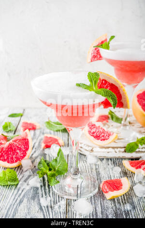 Sommer Trend Alkohol trinken. Kalte citrus Martini Cocktail. Aperol Spritz, mit frischer Grapefruit und Minze. Holz- weißer Hintergrund, Kopie Raum Stockfoto