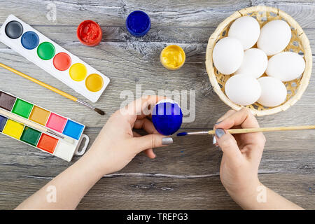 Weiße Eier, Farben, Quasten, Vorbereitung für die Färbung für Ostern. Frauen Hände malen Eier zu Ostern Stockfoto