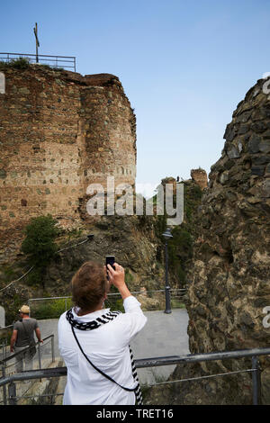 Eine Frau ein Foto af eine alte Kirche in Tiflis. Georgien Stockfoto