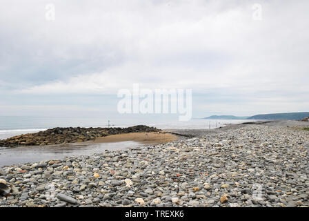 Eine Strandszene in Borth, Wales, UK, Felsen als Teil der Borth sea Abwehr platziert Projekt Stockfoto