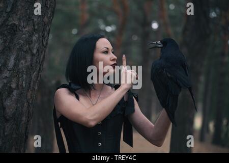 Mädchen und Raven im Wald. fabelhaft themed Fotoshooting Stockfoto