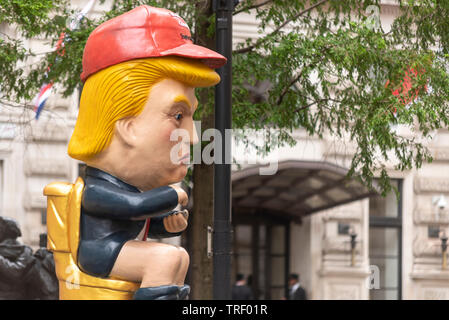 Die Demonstranten haben außerhalb der Corinthia Hotel, Westminster, London, UK, wo Donald Trump angeblich hat eine ganze Etage für seine Familie gebucht. Ein Bildnis des Donald Trump twittern, während auf einer Toilette saß Prominente Stockfoto