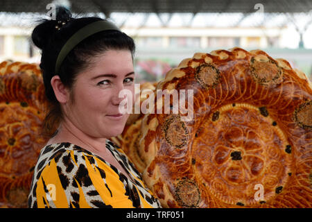 Margilan, Fergana-tal, Usbekistan - 4. Juni 2019: Frau verkaufen USBEKISCHEN Brot, nicht oder lepeshka, die rund und flach und wird im tandyr, in der Stockfoto