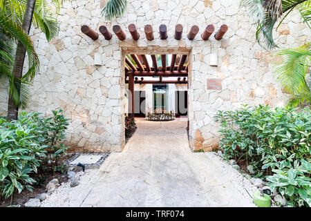 Der Eingang zu einem der Gebäude, umgeben von Pflanzen, Valentin Imperial Maya All inclusive Resort. Stockfoto