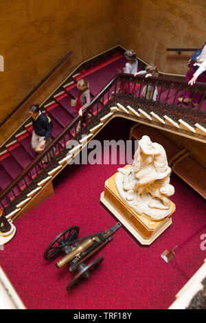 Innen/Innen von Osborne House auf der Isle of Wight; am Fuße der wichtigsten Auftraggeber Treppe die Statue "Die Amazonen und Argonaut" ist auf dem Display neben einem alten Barrel Of A Gun Cannon. Isle of Wight, Großbritannien Stockfoto