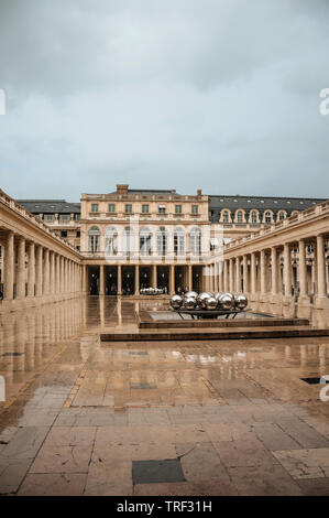 Gebäude und Innenhof mit modernen Skulptur an regnerischen Tag im Palais Royal in Paris. Einer der kulturellen Zentrum der eindrucksvollsten Welt in Frankreich. Stockfoto