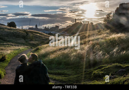 Liebhaber genießen die dramatischen Licht über dem Holyrood Park Calton Hill Stockfoto