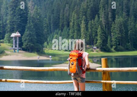 Touristische Mädchen und Bergblick am See Synevyr. Karpaten, Ukraine. wunderschöne Landschaft Stockfoto